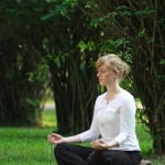woman meditating in park