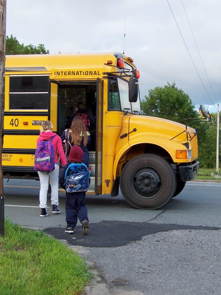 kids getting on a school bus