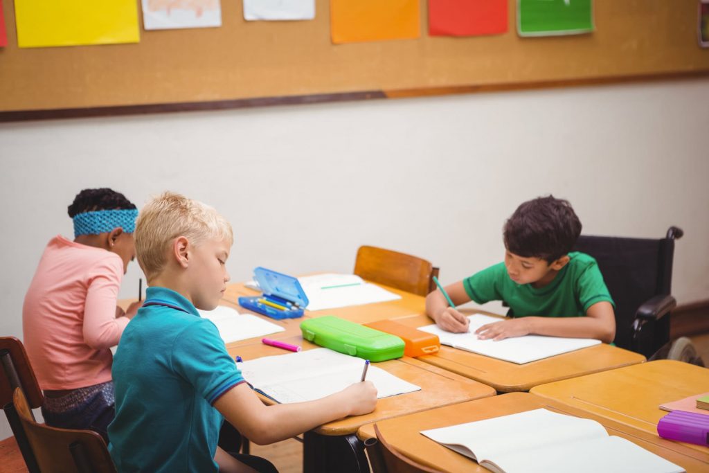 School children working in a classroom at desks. School Truancy, School Avoidance, School Anxiety, School Refusal