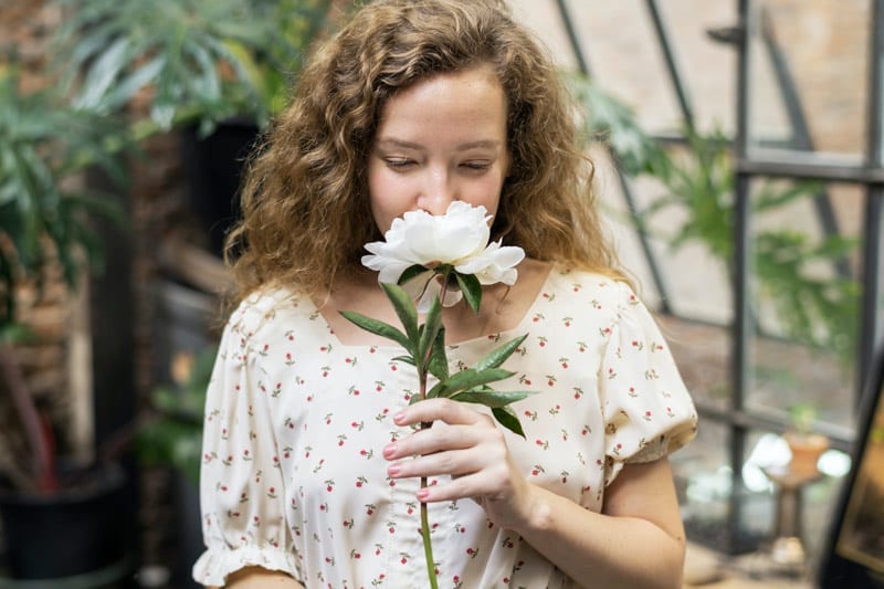 woman smells a flower