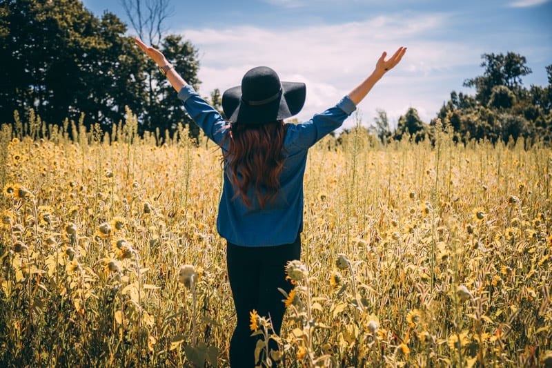 grateful woman in field of flowers