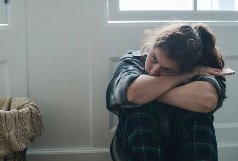 sad teen with smartphone.