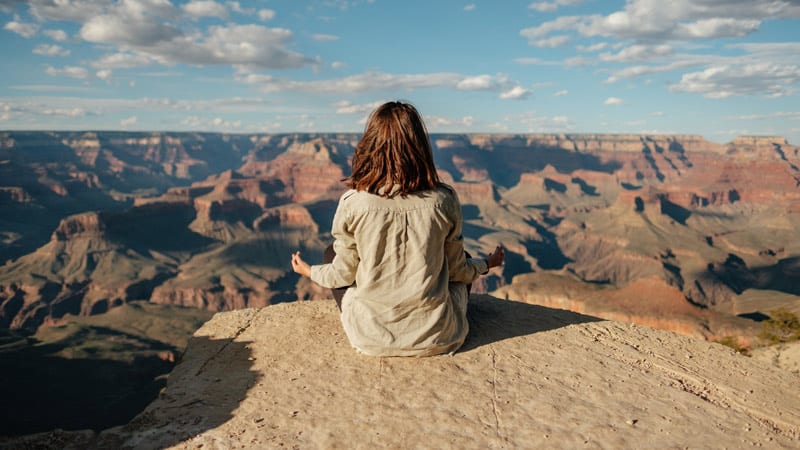 young woman meditating at Grand Canyon