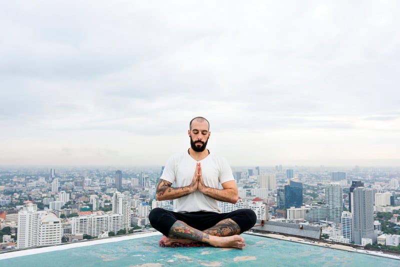 man doing rooftop meditation