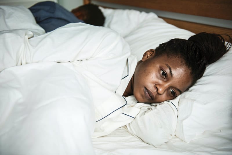 anxious black woman in bed