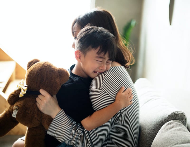 mother hugging crying child