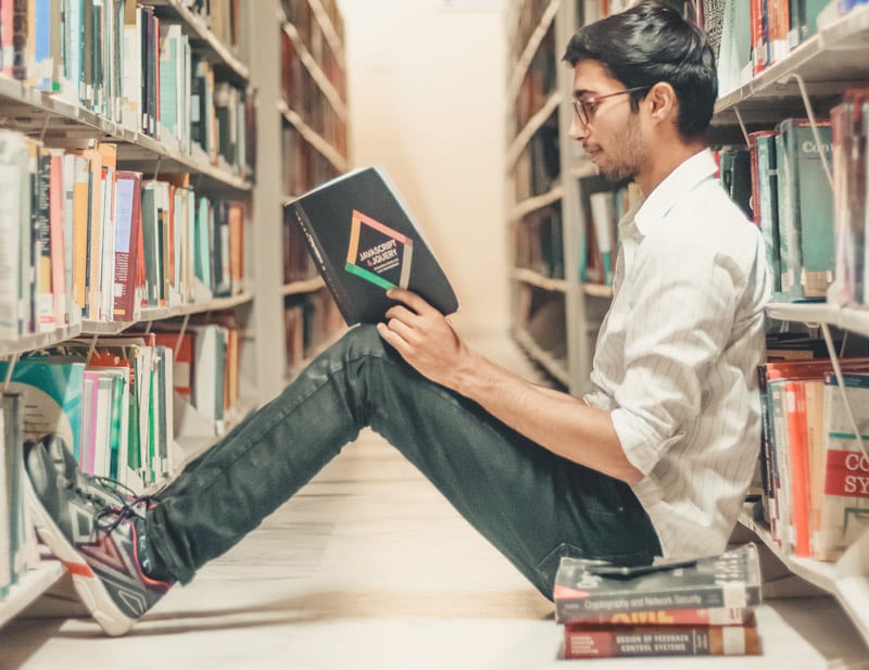 young adult reading in library