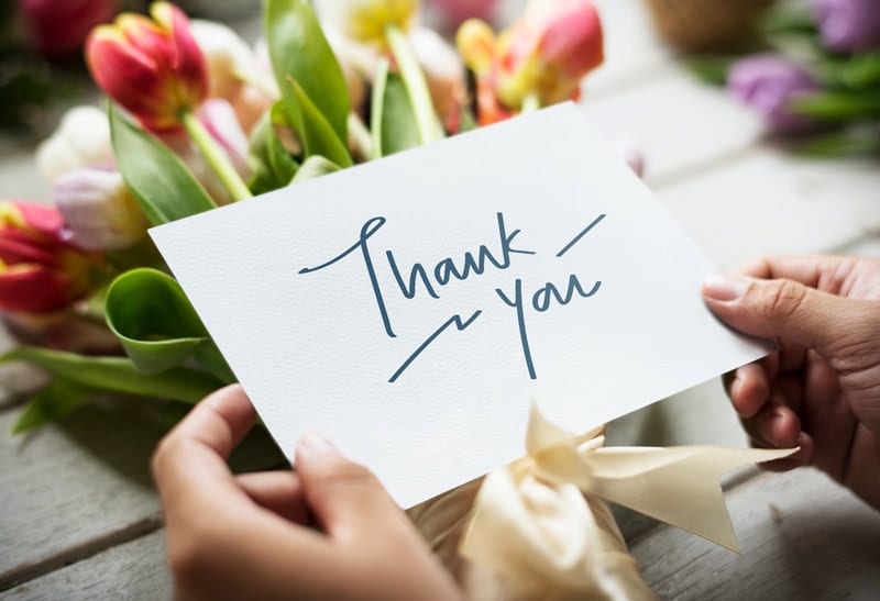 thank you note with flowers in background