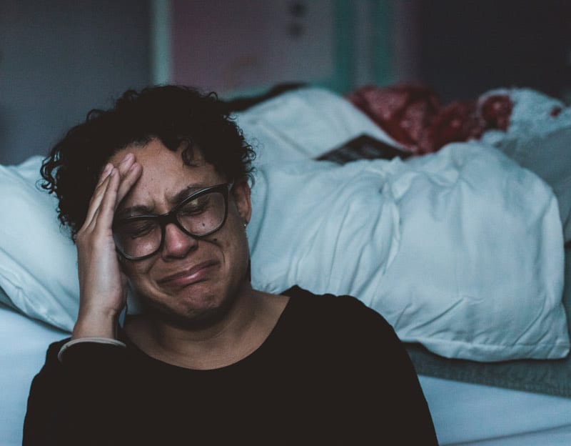 crying woman beside bed