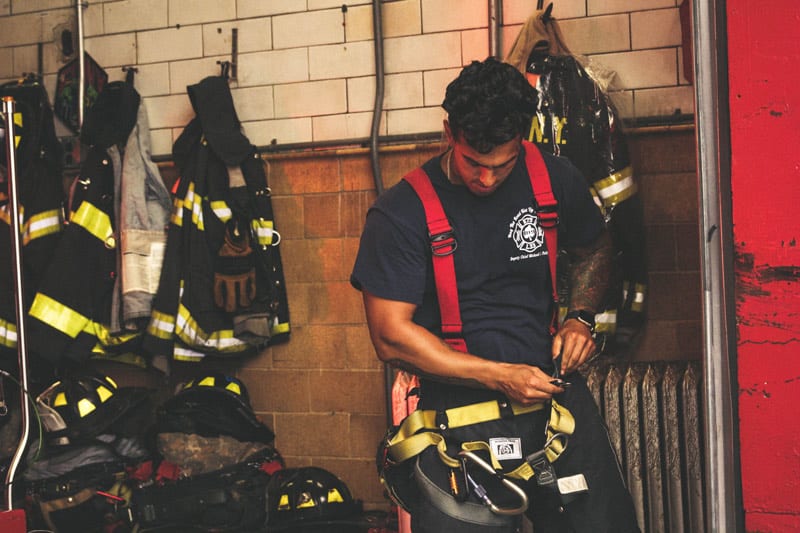 male firefighter gearing up.