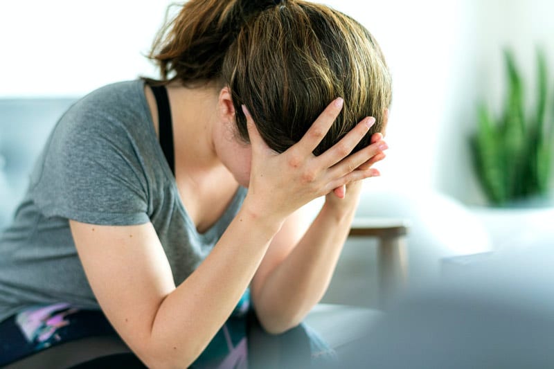 anxious woman with head in hands