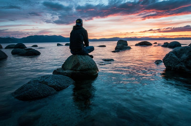 man on rocks in water