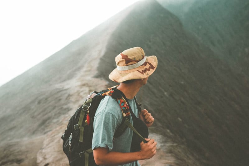 young backpacker at base of mountain