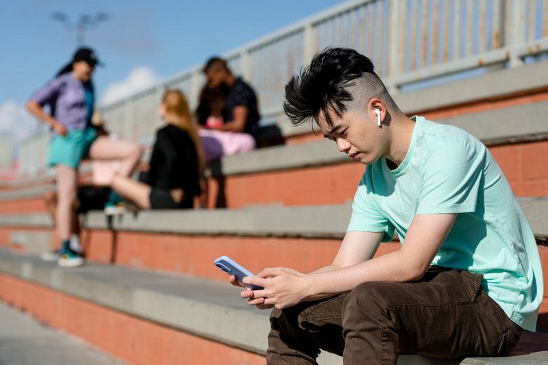 teen sitting apart from others