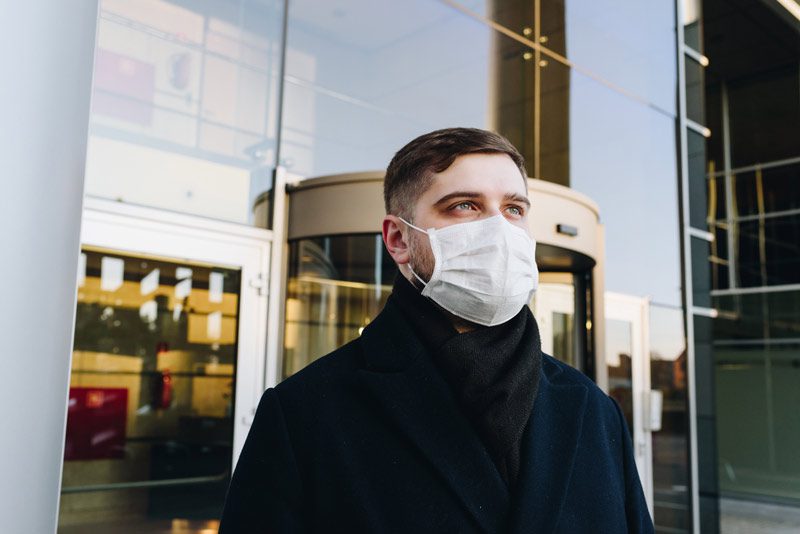 masked man in front of office building