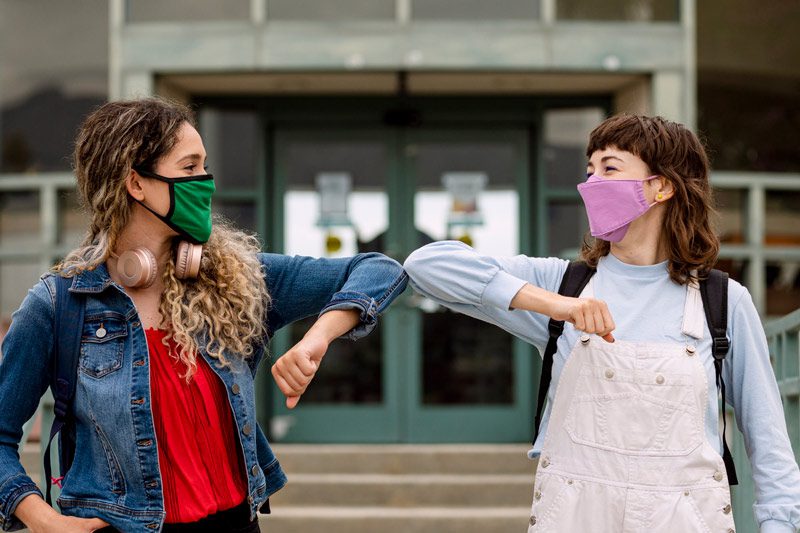 young women elbow bump