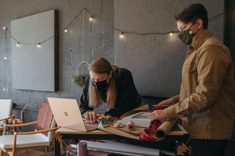 friends wrapping holiday gifts