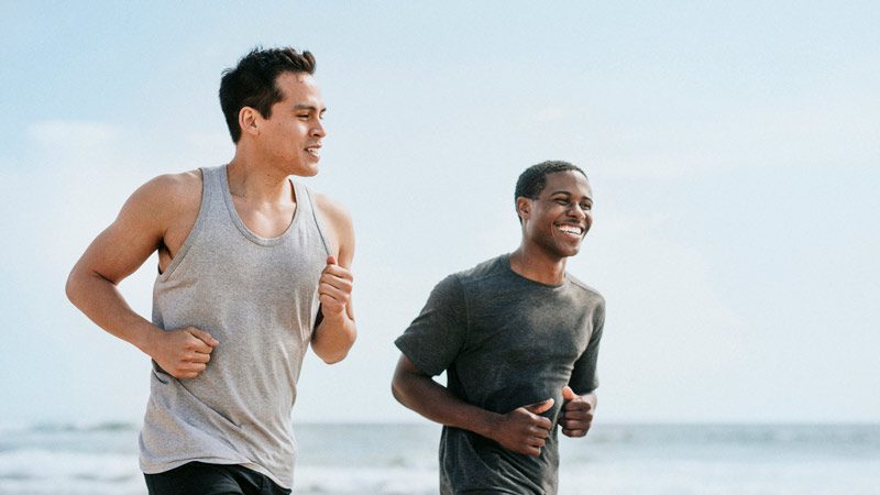 two friends running on beach