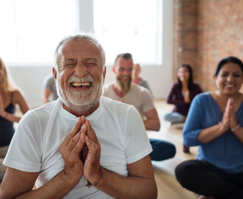 happy older man in yoga class