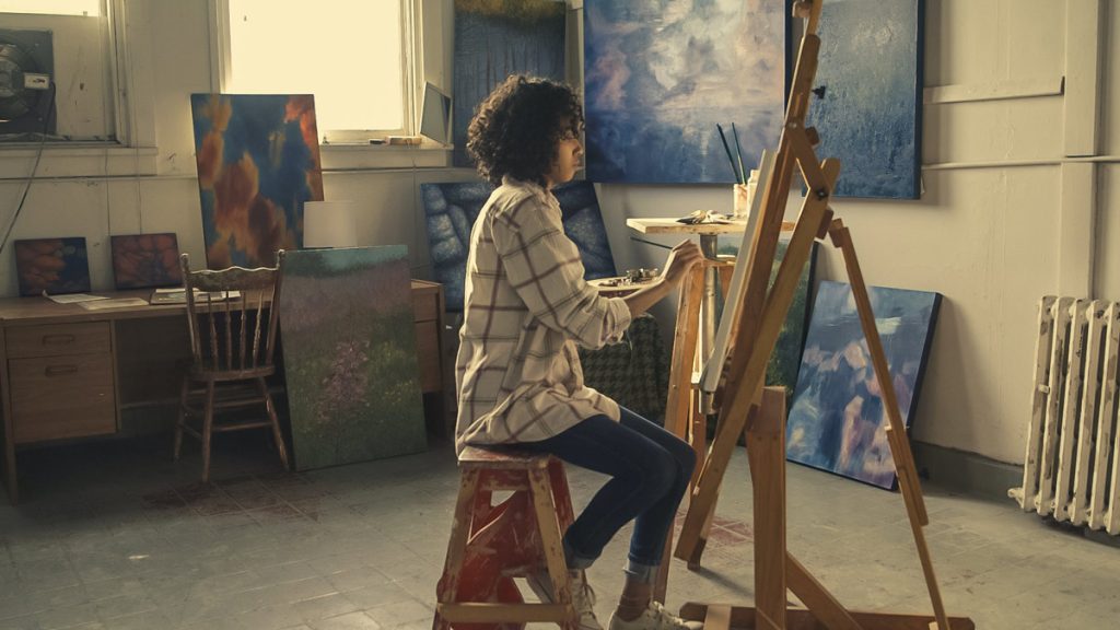 young woman painting a canvas.