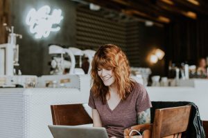 red haired woman using laptop