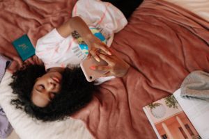 teen girl on bed with smartphone