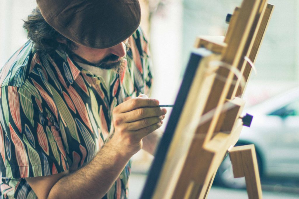 man in beret painting