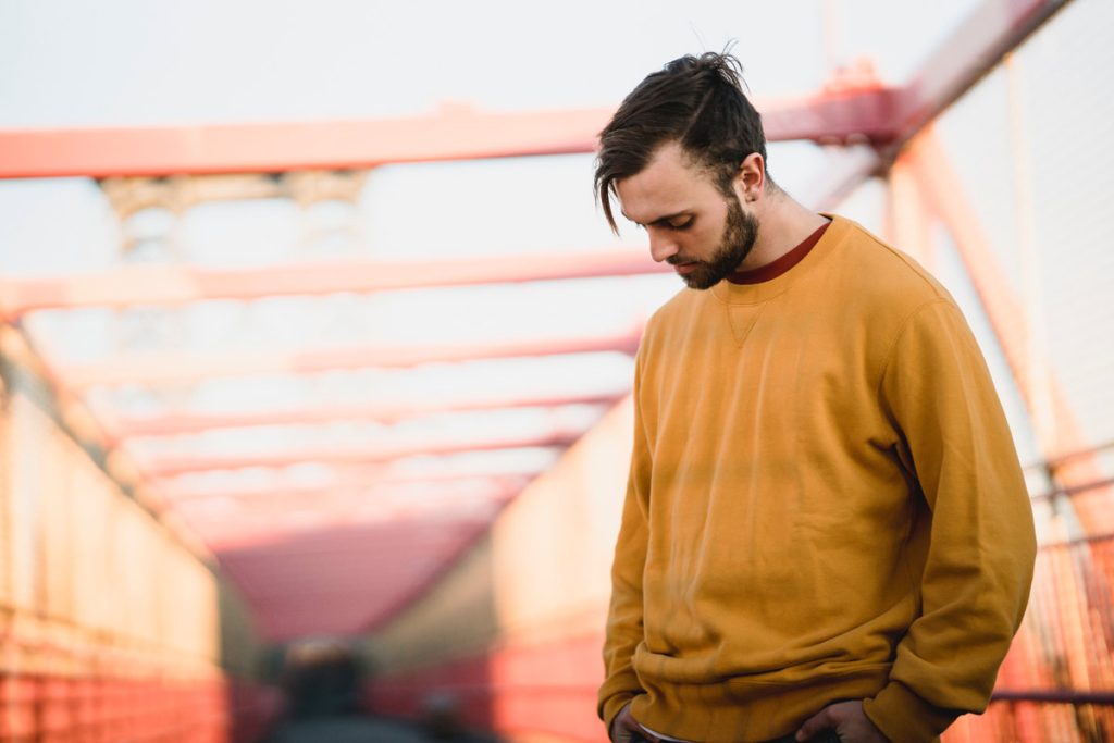 pensive man in orange shirt