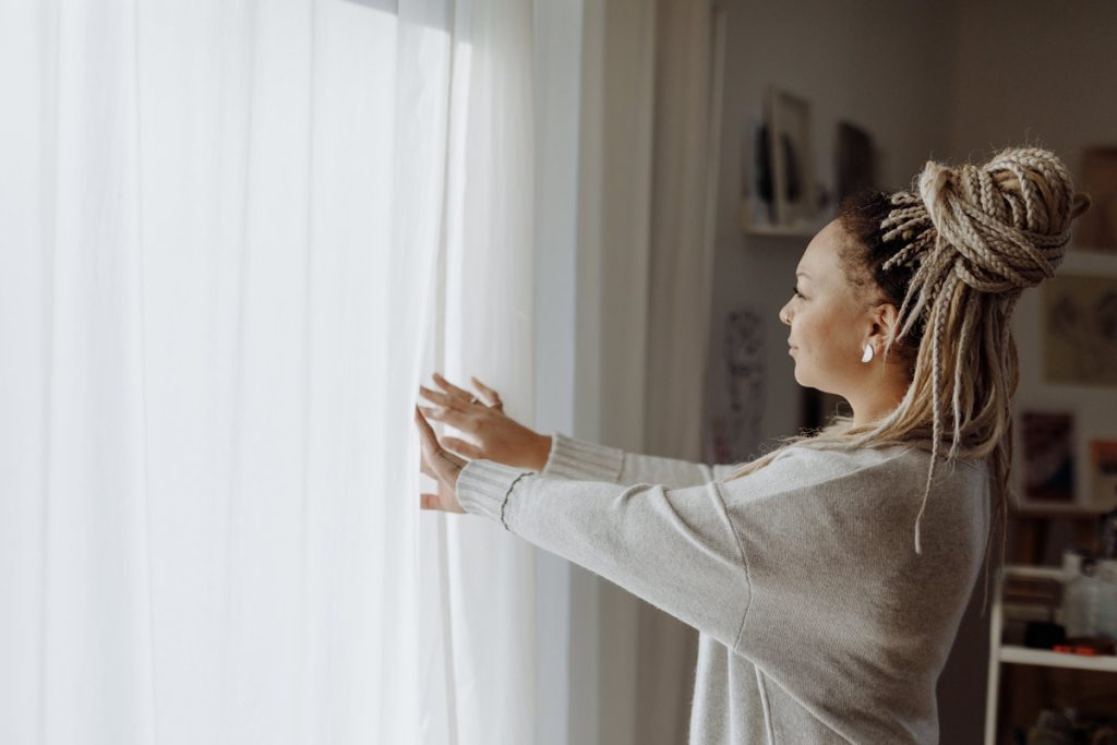 women with braided hair at window