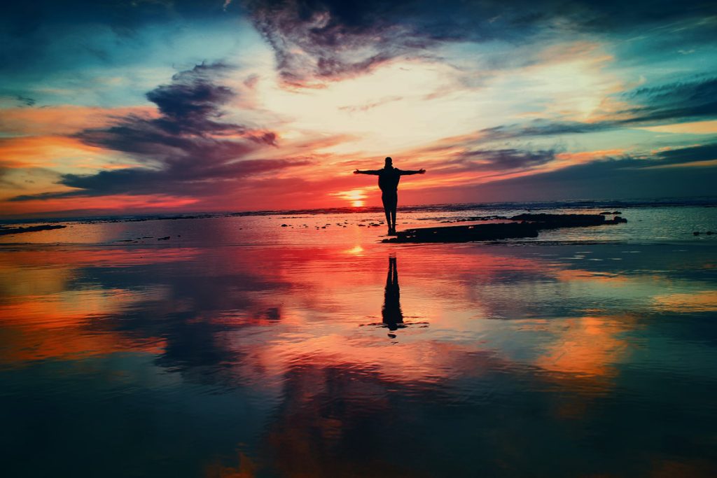 person standing before sunset