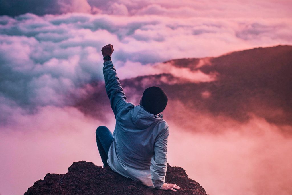 triumphant person on mountop at sunrise