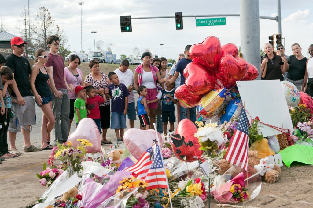 Strangers hold hands at Aurora, CO memorial