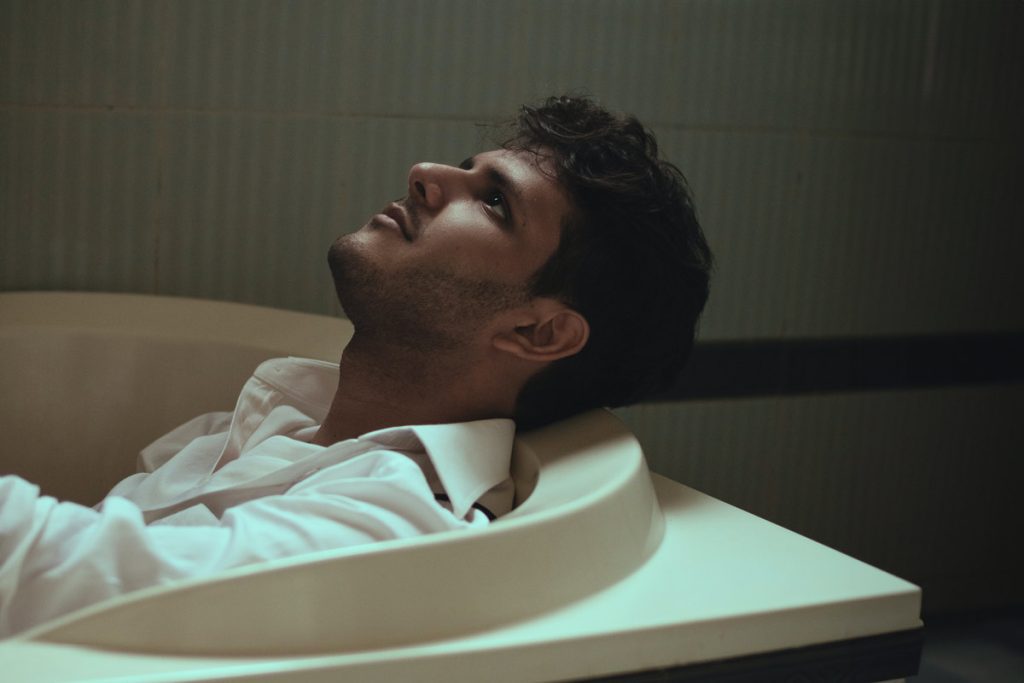 depressed man sitting in bathtub