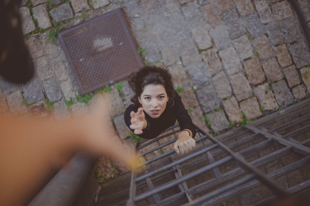 helping hand to woman on ladder