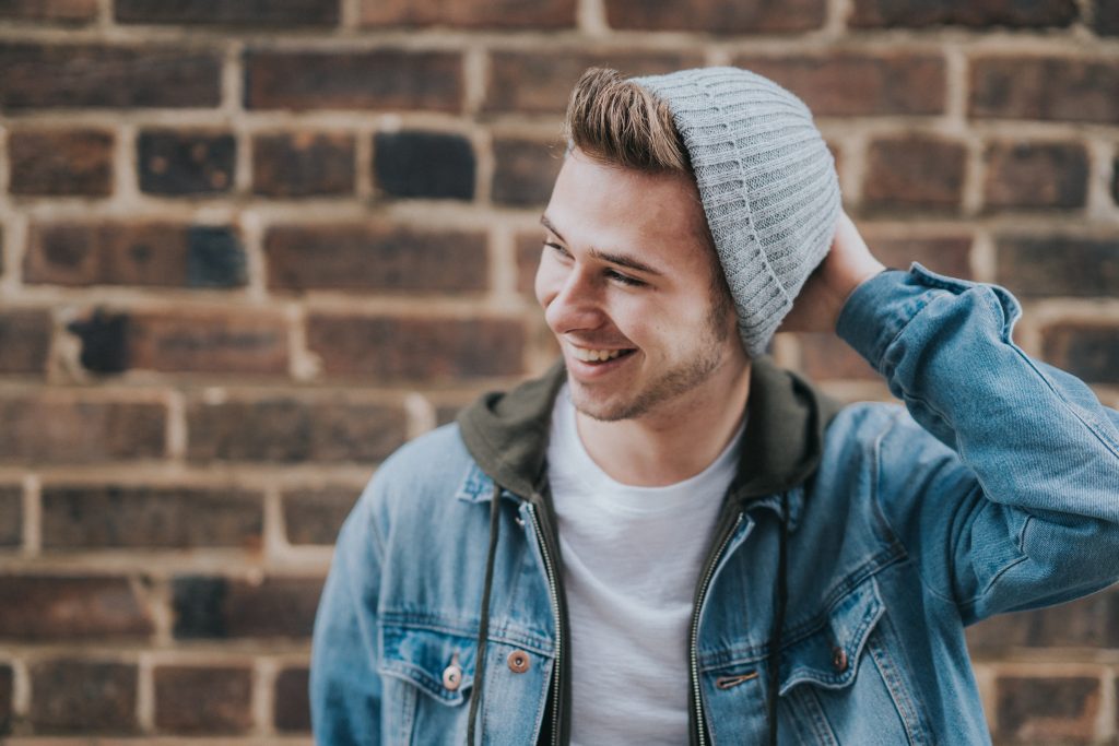 smiling man in cap and denim