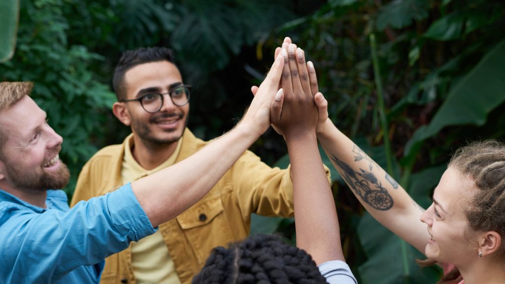 four friends high-fiving