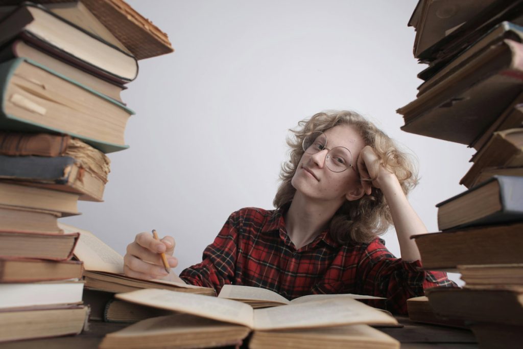 student surrounded by books