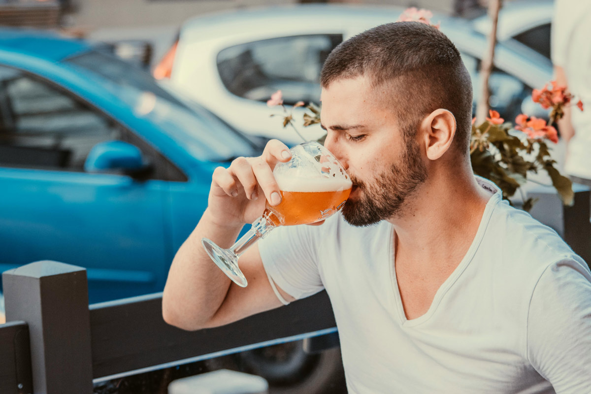 man drinking glass of beer