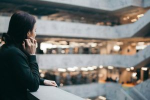 Lonely woman staring into the open concourse of a shopping mall