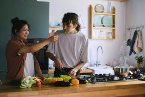 Man and woman preparing healthy food in kitchen.