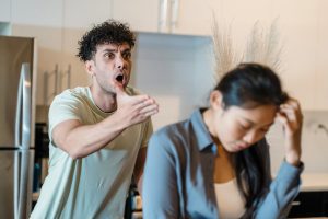 Angry man yelling at upset woman