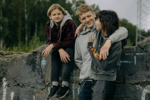 Three teens hanging out outdoors, symbolizing peer group dynamics and social pressure among adolescents