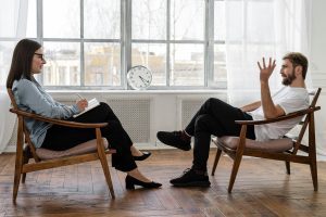 Therapist listening to a male client in a talk therapy session.