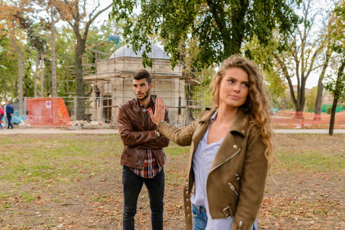 Couple standing outside experiencing emotional conflict and distance.