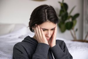 Worried woman with head in her hands, showing the emotional impact of catastrophizing.