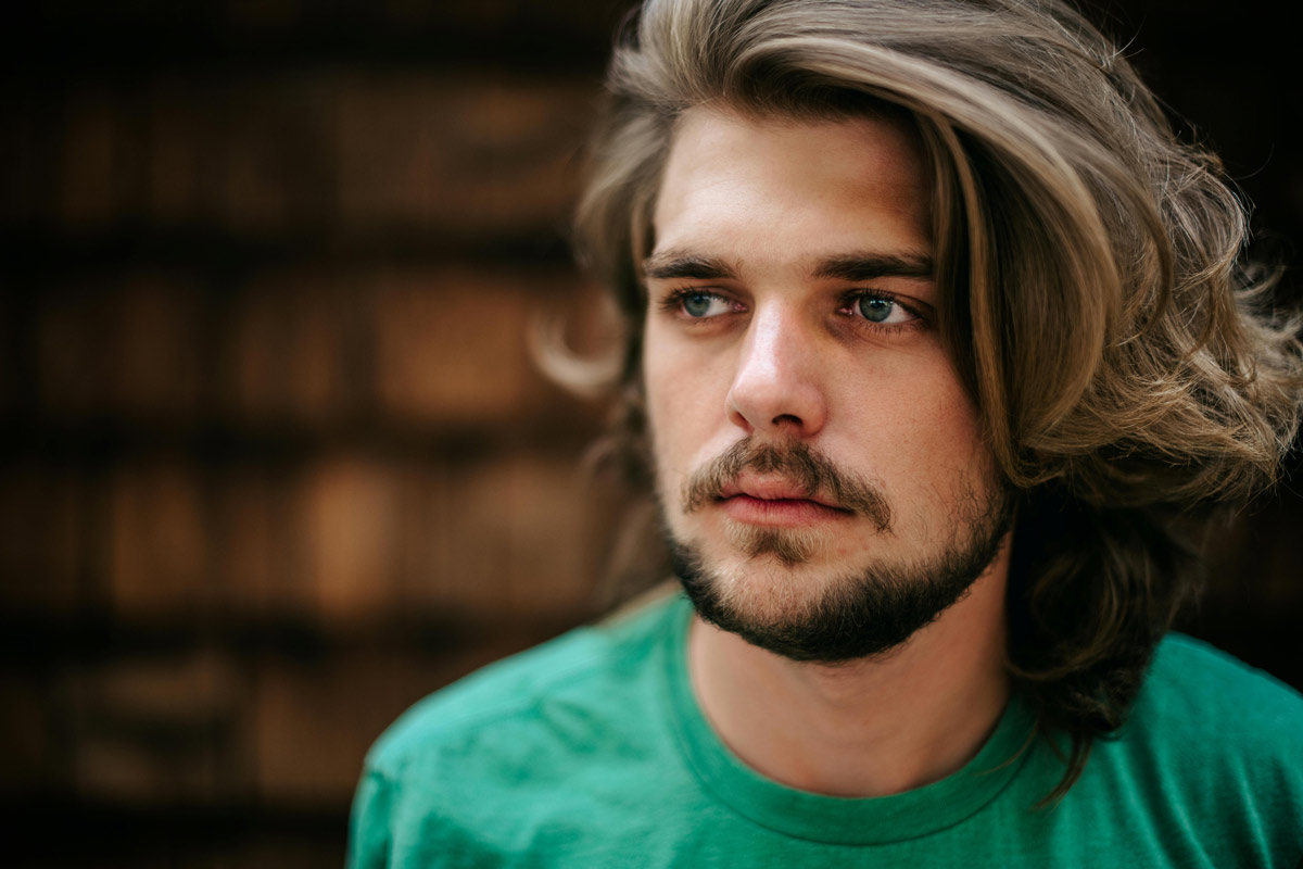 Portrait of a reflective man with a beard, symbolizing emotional depth and vulnerability in addiction recovery.