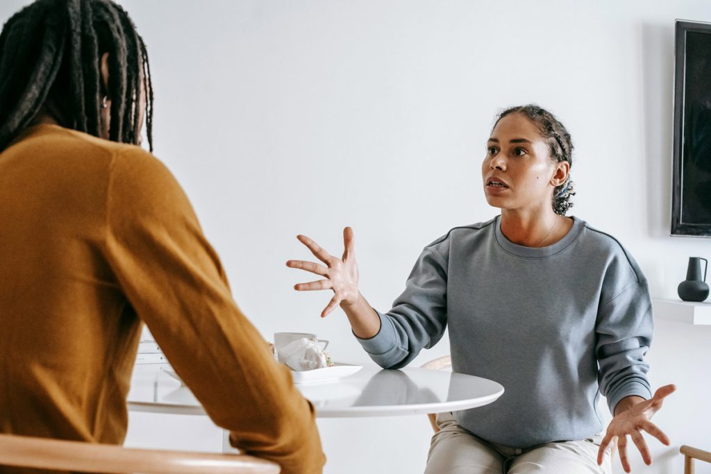 African American couple having a serious discussion at a table, representing the challenges of setting boundaries in family relationships and the importance of healthy communication.