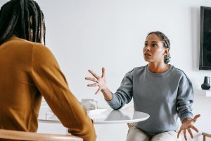 African American couple having a serious discussion at a table, representing the challenges of setting boundaries in family relationships and the importance of healthy communication.