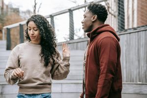 Two people having a serious conversation, one looking concerned while the other appears guarded, illustrating the challenge of recognizing hidden emotional struggles