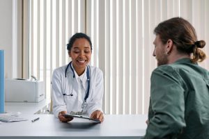 Healthcare provider consulting with patient about addiction treatment options in a bright, welcoming medical office.